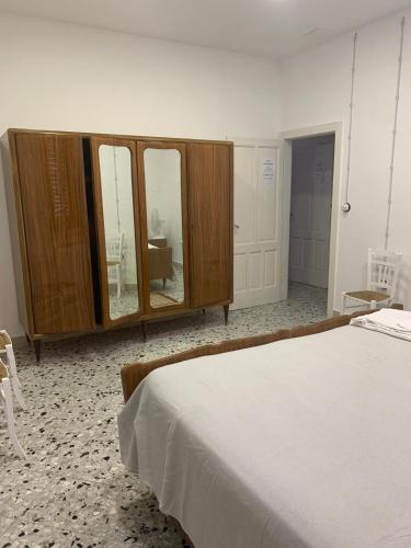 a bedroom with a bed and a dresser with mirrors at Bed & Breakfast StudioArcodia- in San Marco dʼAlunzio