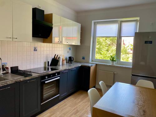 a kitchen with blue cabinets and a table at Apartament Horeszków by Prestige Home in Szczecin