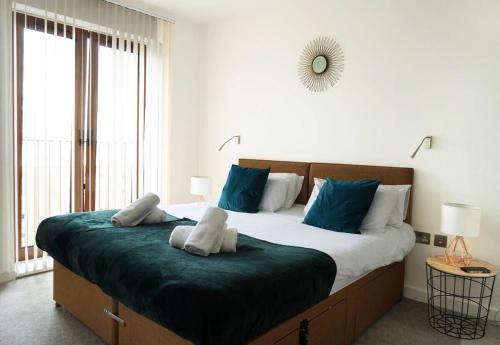 Un dormitorio con una cama grande con almohadas azules. en Luxury Flat 1 Bedroom Flat I Working Professionals & Contractors I Flat 86, en Saint Albans