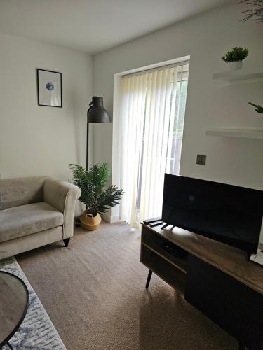 a living room with a couch and a flat screen tv at Sotys Contractors, Long and Short term stays in Derby