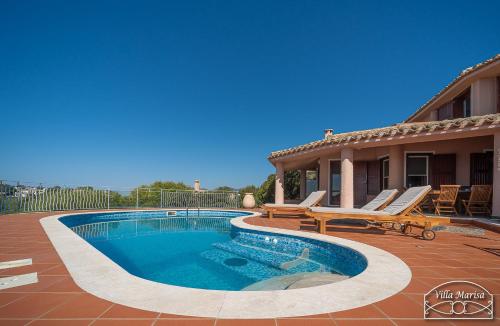 a swimming pool with two chairs and a house at Villa Marisa in Torre delle Stelle