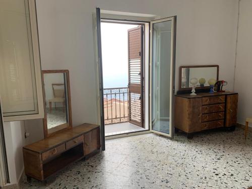 a room with a mirror and a dresser and a balcony at Bed & Breakfast StudioArcodia- in San Marco dʼAlunzio