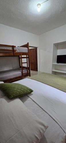 a bedroom with a bed and a bunk bed at Palmendros Hosteria in Montañita