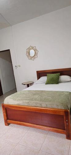 a bed with a wooden frame in a room at Palmendros Hosteria in Montañita