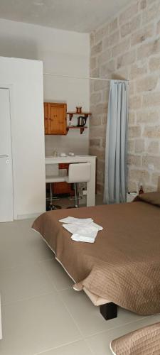 a bedroom with a bed and a desk and a sink at Panorama City in Conversano