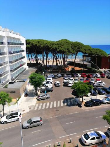 a parking lot with cars parked next to the beach at Estudio la Pineda playa in La Pineda