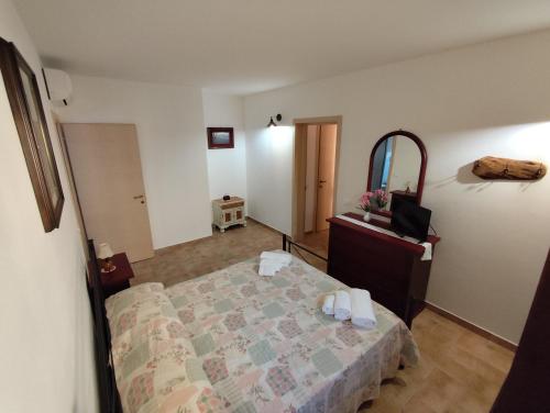 a bedroom with a bed and a dresser and a mirror at Agriturismo Campo alla Cantina appartamento Papavero-Malva in Gavorrano