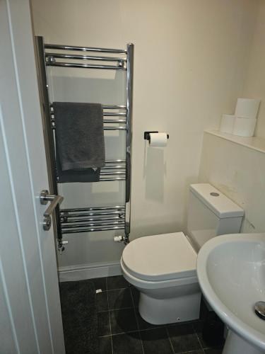 a white bathroom with a toilet and a sink at Sotys Contractors, Long and Short term stays in Derby