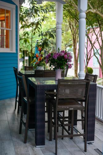 a table and chairs on a porch with a vase of flowers at 4 BR - Sleeps 8! Best location next to Bourbon Street! in New Orleans
