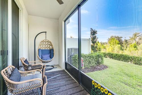 a porch with two chairs and a swing at Wesley Chapel End Unit with Patio and Nature Views! in Wesley Chapel