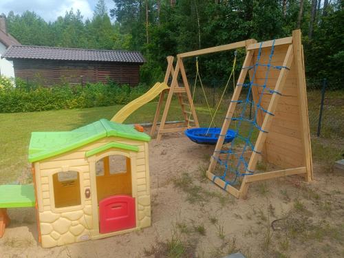 three childrens play sets in a sandbox with a swing at Kaszubski dom pod lasem in Studzienice