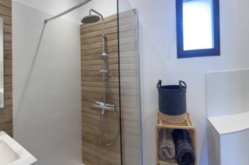 une douche dans une salle de bain avec une porte vitrée dans l'établissement Villa Saint Quentin La Poterie, à Saint-Quentin-la-Poterie