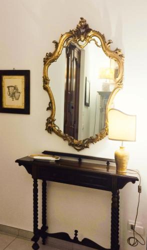 een spiegel bovenop een tafel met een lamp bij Casa Vacanza -Trani centro in Trani