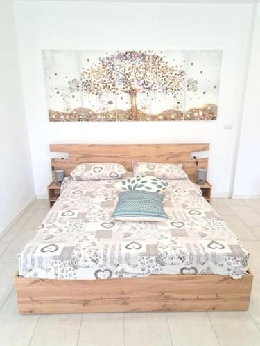 a bedroom with a bed with a tree on the wall at Esther house monolocale in Terlano