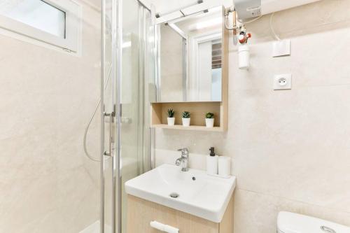 une salle de bain blanche avec un lavabo et une douche dans l'établissement Studio 5mn walk from Oberkampf metro station, à Paris