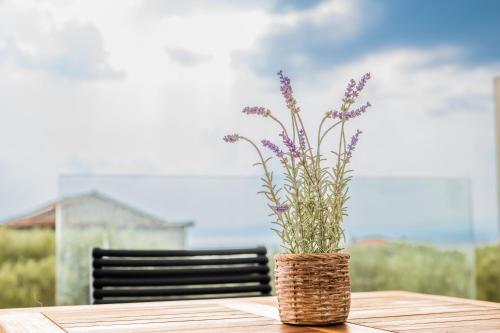 a vase with purple flowers sitting on a table at Petradi Suites in Kalamata