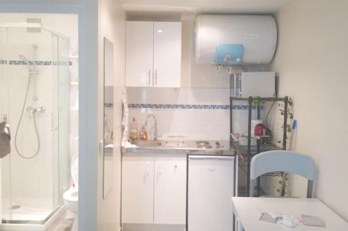 une petite cuisine avec des armoires blanches et un évier dans l'établissement Near Eiffel Tower - Paris, à Paris