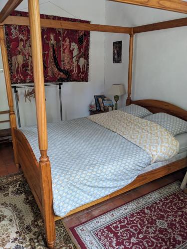 - une chambre avec un lit doté d'un cadre en bois dans l'établissement chambre d'hôte La Fontaine, à Saint-Michel-Lapujade