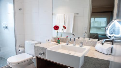 a bathroom with a sink and a toilet and a mirror at Quality Porto Alegre in Porto Alegre