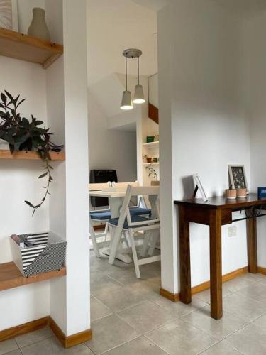 Una sala de estar con un escritorio y una mesa con una computadora. en Duplex con Excelente ubicación, en Esquel