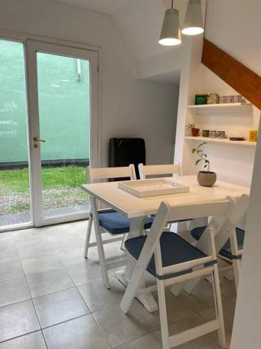 Una mesa y sillas blancas en una habitación con ventana. en Duplex con Excelente ubicación, en Esquel