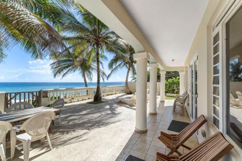 a patio with a table and chairs and the ocean at Sandy Beach Villa - Spectacular setting on the beach (full service generator) in Rincon