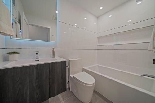a bathroom with a toilet and a tub and a sink at Huge 2000 sqft Luxury & Stylish Condo minutes to New York in Jersey City