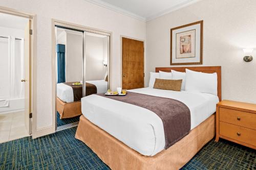 a hotel room with a large bed and a bathroom at Best Western De Anza Inn in Monterey