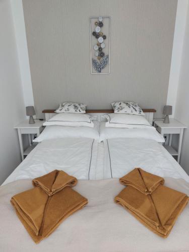 a bed with two brown towels on top of it at Három Testvér Apartman in Siófok