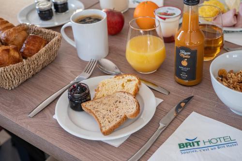 a table topped with a plate of bread and toast at Brit Hotel Angers Parc Expo - L'Acropole in Saint-Sylvain-dʼAnjou