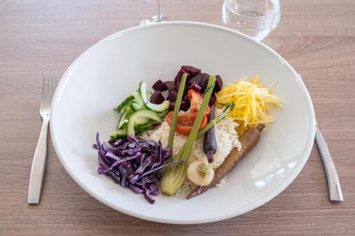 a plate of food with vegetables on a table at Brit Hotel Angers Parc Expo - L'Acropole in Saint-Sylvain-dʼAnjou