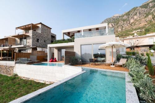 a villa with a swimming pool and a house at Petradi Suites in Kalamata