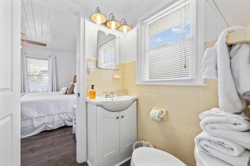 a bathroom with a sink and a toilet and a bed at A Boardwalk Away in Myrtle Beach
