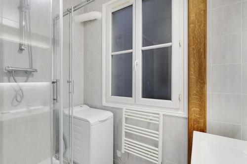 une salle de bain blanche avec toilettes et douche dans l'établissement GoodGuest- Paris Levallois Bail Mobilité, à Levallois-Perret