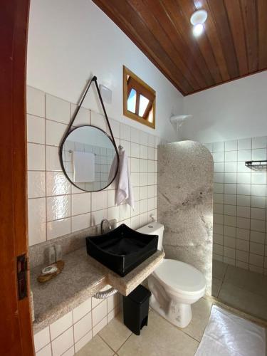 a bathroom with a sink and a toilet and a mirror at Pousada Oceano Atlântico in Marau