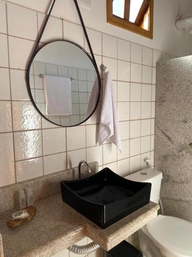 a bathroom with a black sink and a mirror at Pousada Oceano Atlântico in Marau