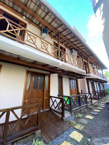 a house with wooden doors and a balcony at Pousada Oceano Atlântico in Marau