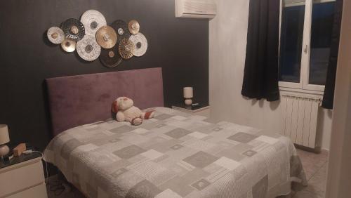 - un ours en peluche assis sur un lit dans une chambre dans l'établissement Les plaisirs de camargues, à Aimargues