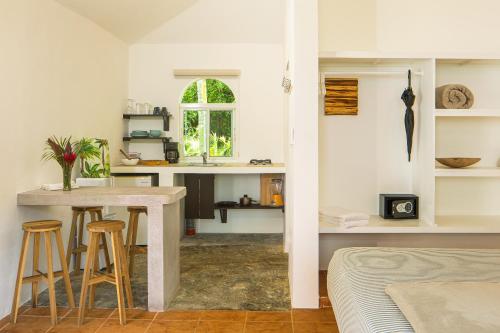 a kitchen and living room with a table and stools at El Encuentro Surf Lodge in Cabarete
