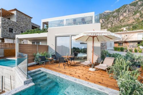 a house with a swimming pool and an umbrella at Petradi Suites in Kalamata
