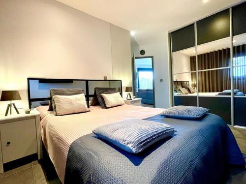 une chambre avec un grand lit avec des oreillers dessus dans l'établissement Le Loft Cosy Chic - Contemporain, Clim, Wifi, 6 pers, à Istres