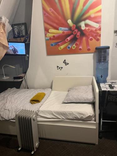 - un petit lit dans une chambre ornée d'une peinture murale dans l'établissement Chambre Arc Triomphe Champs Elysees, à Paris