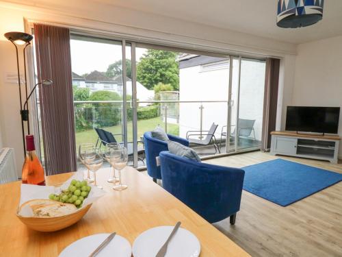 a dining room with a table and chairs and a television at 28 Coedrath Park in Saundersfoot