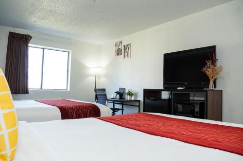 a hotel room with two beds and a flat screen tv at Victorian Inn & Suites-York in York