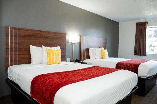 a hotel room with two beds with red and white sheets at Victorian Inn & Suites-York in York