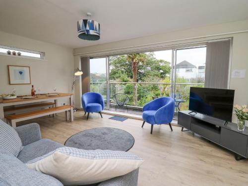 a living room with a couch and chairs and a television at 36 Coedrath Park in Saundersfoot