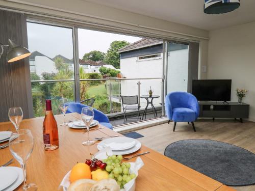 a dining room with a table with fruits and wine glasses at 36 Coedrath Park in Saundersfoot