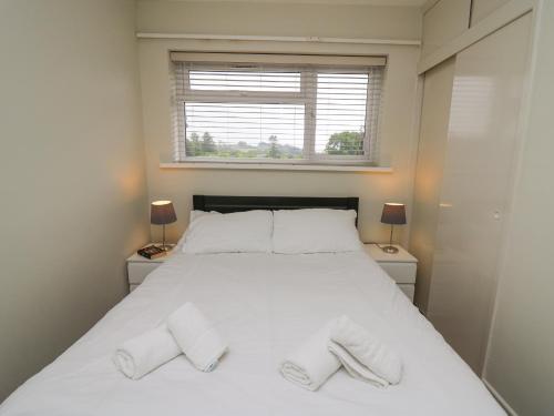 a bedroom with a bed with two slippers on it at 36 Coedrath Park in Saundersfoot