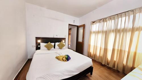 a bedroom with a large bed with white sheets at Munnar Bethel Varkis Heritage Resort in Munnar