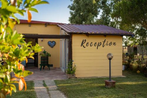 a yellow shed with a sign that reads reception at Terre Dell'Amore in Grosseto